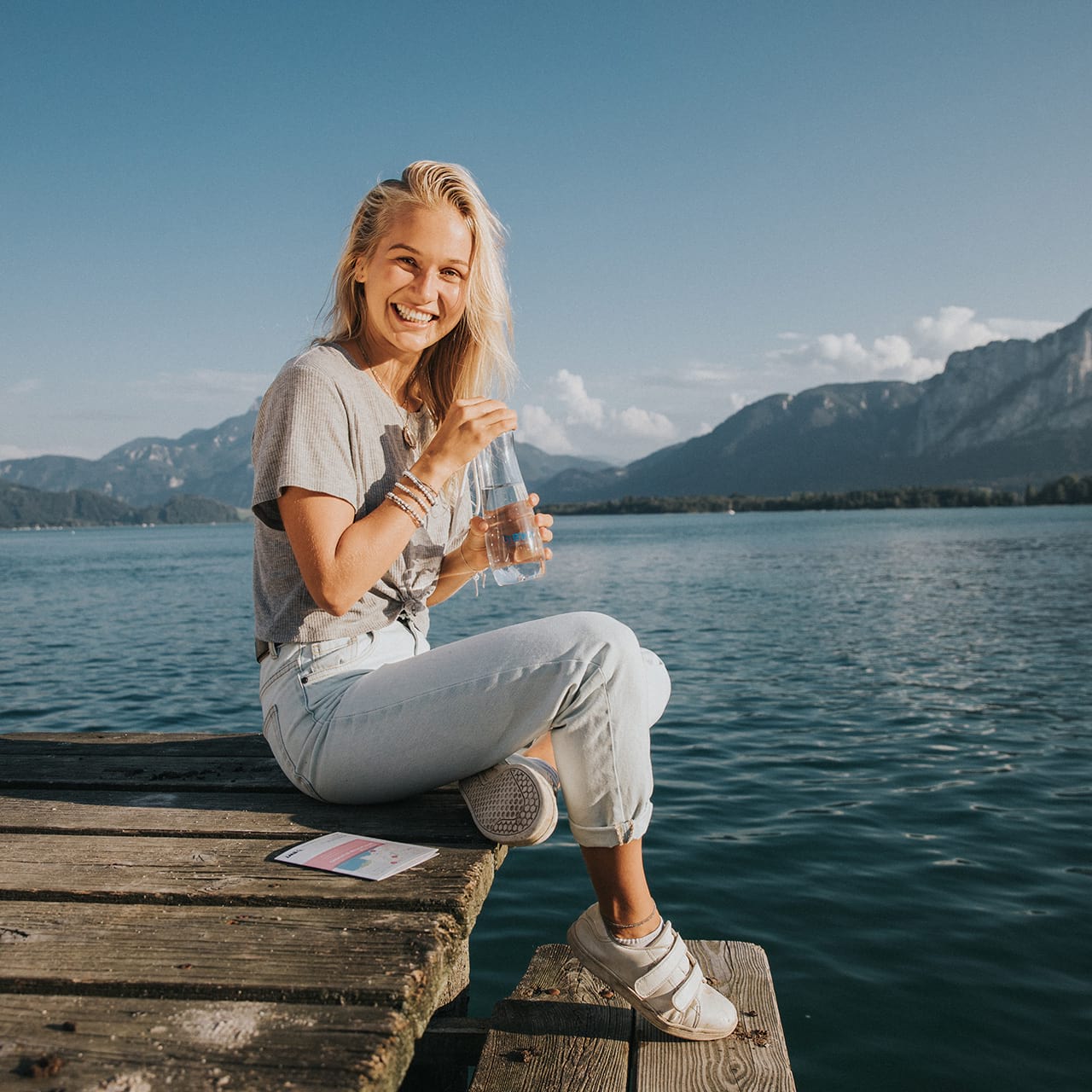 femme au bord d'un lac boit de l'eau